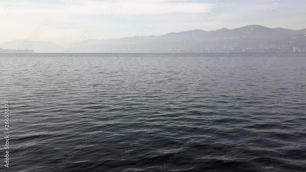 An aerial shot flying over a lake in northern Italy fast and close to the water. An aerial shot flying over a lake in northern Italy fast and close to the water.