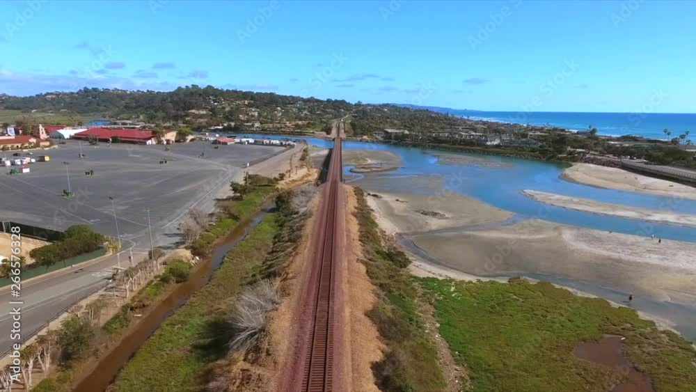 Aerial, rising, drone shot, above train tracks, overlooking houses and buildings on the coast of the Pacific ocean, on a sunny day, in San Diego California, USA Aerial, rising, drone shot, above train tracks, overlooking houses and buildings on the coast of the Pacific ocean, on a sunny day, in San Diego California, USA