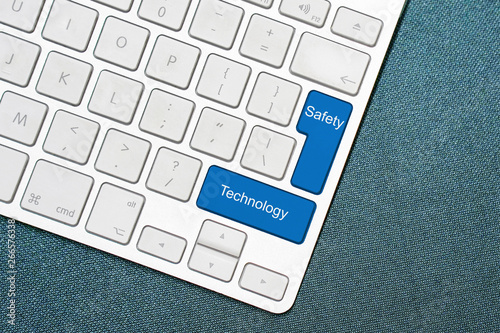 Computer keyboard and blue key with words Safety and Technology. photo