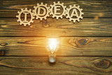 Gears, idea, light bulb on wooden background. the concept of the business idea.