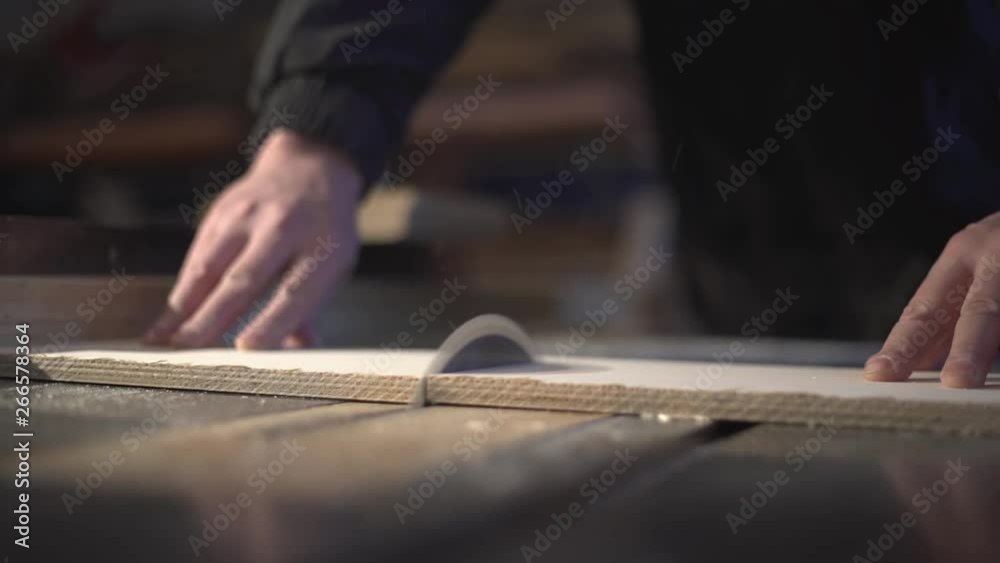 The carpenter saws the boards on a circular saw. Carpentry workshop The carpenter saws the boards on a circular saw. Carpentry workshop