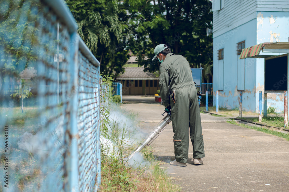 Man work fogging to eliminate mosquito for preventing spread dengue fever in the community