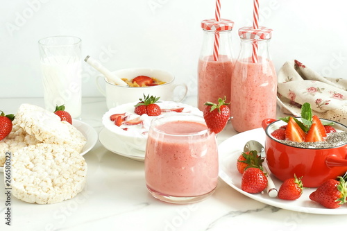 Strawberry smoothie or milkshake in a glass on marble background. Healthy food for breakfast and snack. copy space