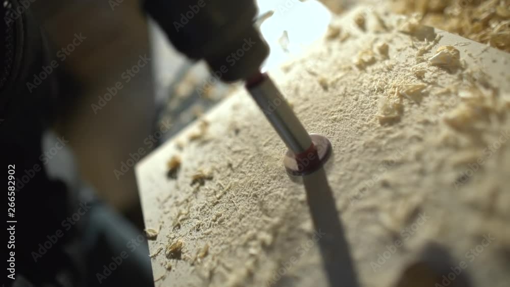 Close up of Wood Worker using an electric hand drill to drill a hole through the bracket Close up of Wood Worker using an electric hand drill to drill a hole through the bracket