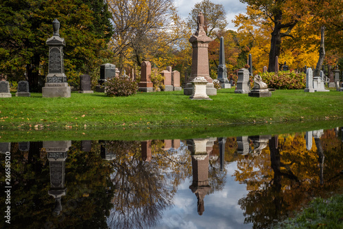Montreal / Canada - Oct. 25, 2017: Autumn reflection and grave stones, Mont-Royal Cemetery, Montreal, Quebec.