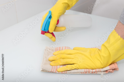 hands with gloves cleaning with spray