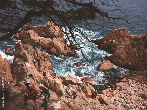 People doing a via ferrata in Sant Feliu de Guixols, Catalunya, Spain (Via ferrata Cala de Molí)
