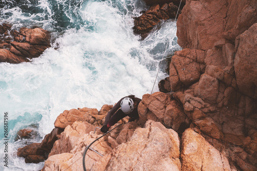 Girl climbing on a Via ferrata, Sant Feliu de Guixols, Catalunya, Spain (Via ferrata Cala de Molí)