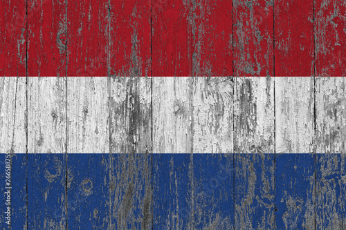 Flag of Netherlands painted on worn out wooden texture background.
