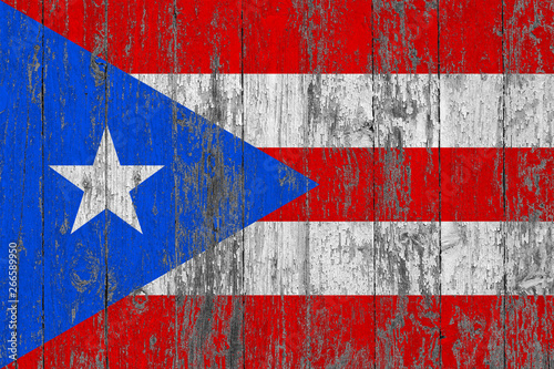 Flag of Puerto Rico painted on worn out wooden texture background.