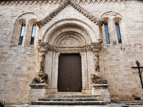 The carved stone entrance with columns of statues and stone lions of the abbey of San Quirico d'Orcia, Italy,