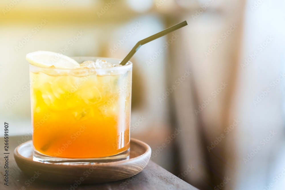 A glass of lemon ice tea on wood plate A glass of lemon ice tea on wood plate