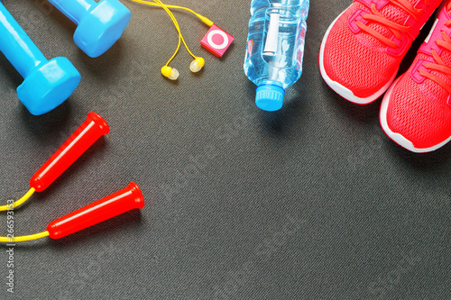 Set of sports accessories for fitness concept with exercise equipment on gray background © Alexander