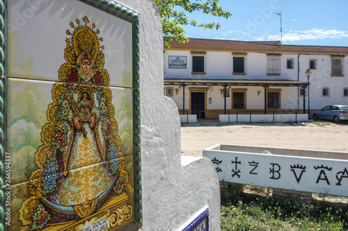 Public fountain with decorative tiles of the Virgen del Rocío and trough for horses with studs marks. El Rocio, Huelva, Andalusia, Spain. photo