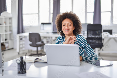 Cute mixed race businesswoman dressed  casual thinking how to solve a problem while sitting in modern office.