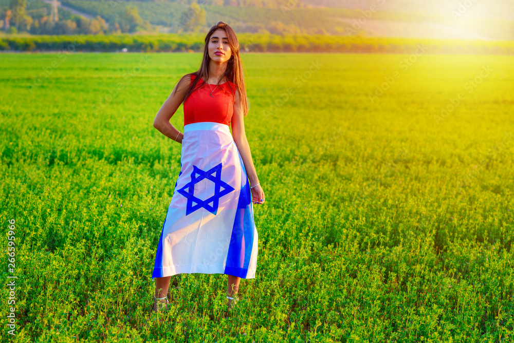 Φωτογραφία Young woman patriot jewish proud girl standing wrapped flag of Israel on amazing landscape in beautiful summer or spring day