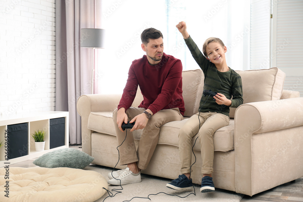 Father and son playing video games at home Father and son playing video games at home