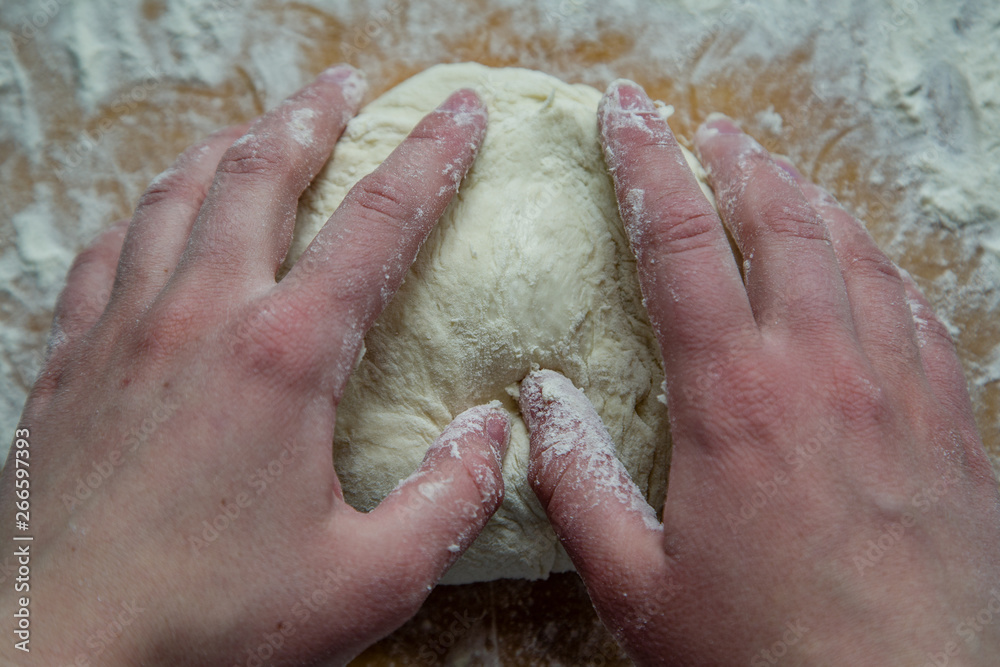 Fototapeta premium chef kneads dough for pizza with his hands