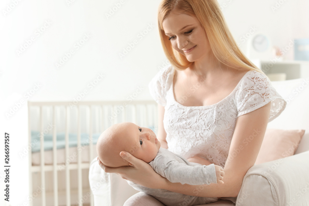 Happy mother with her baby sitting in armchair at home Happy mother with her baby sitting in armchair at home