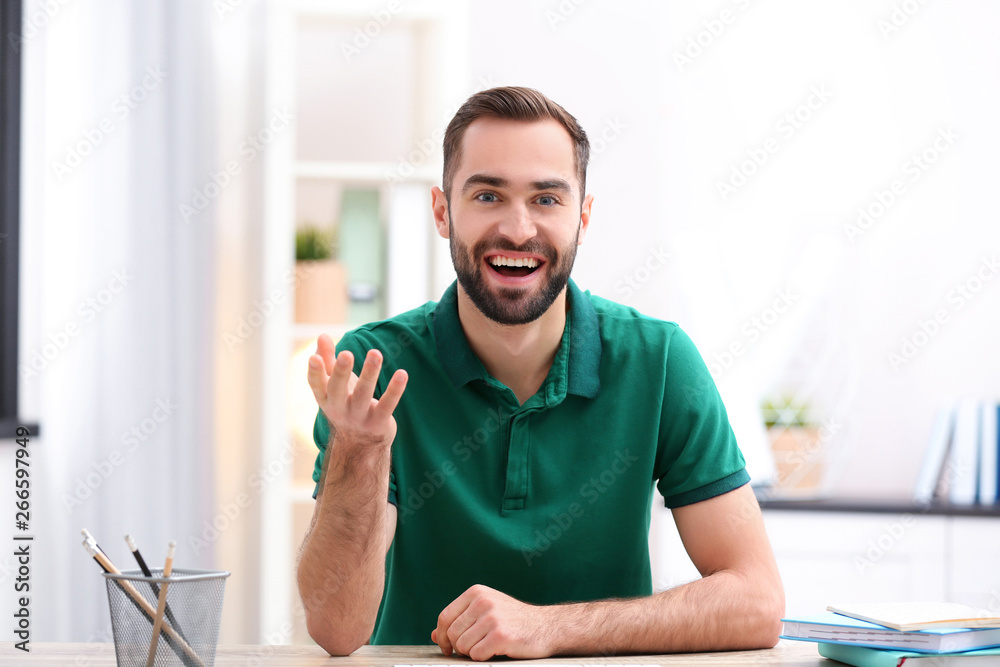 Handsome man using video chat for conversation indoors Handsome man using video chat for conversation indoors
