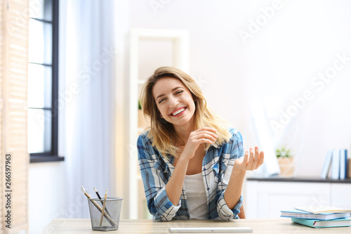 Beautiful woman using video chat for conversation indoors