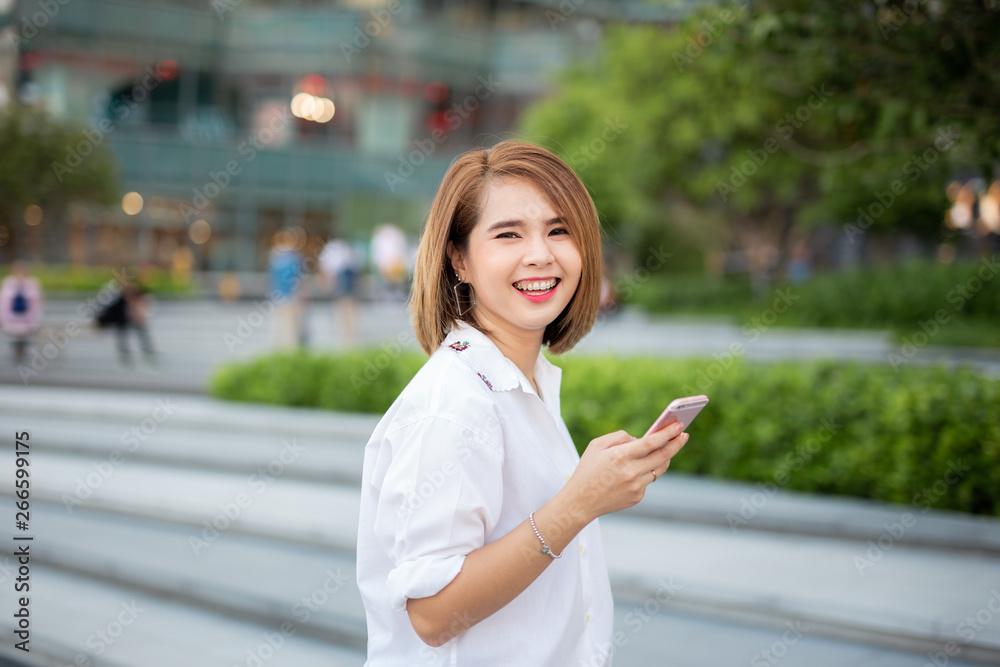 Young beautiful Asian lady celebrate with smart phone in the street in a sunny summer day, success happy pose, internet technology. Young beautiful Asian lady celebrate with smart phone in the street in a sunny summer day, success happy pose, internet technology.