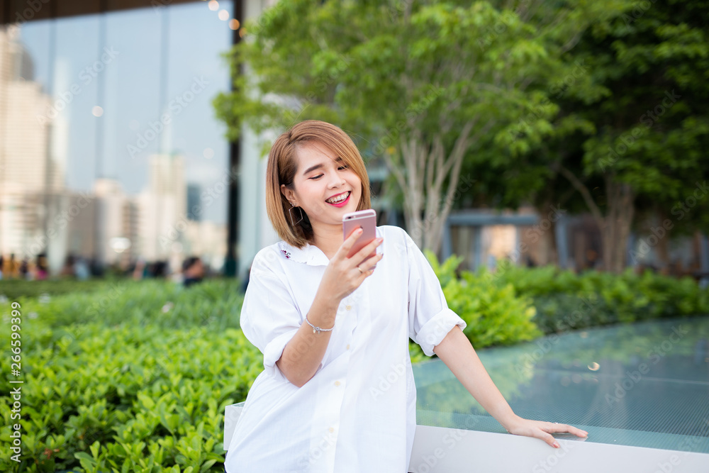 Young beautiful Asian lady celebrate with smart phone in the street in a sunny summer day, success happy pose, internet technology. Young beautiful Asian lady celebrate with smart phone in the street in a sunny summer day, success happy pose, internet technology.