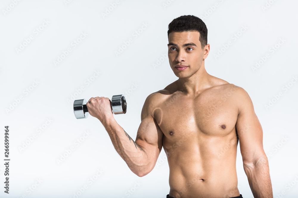 handsome mixed race man with shirtless muscular torso holding dumbbell on white