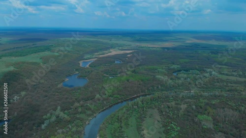 Sunny summer landscape with river.Green hills,fields and meadows.River Medvedica in Volgograd region,Russia.Sunrise.Quiet morning.Calm.Warm sunlight.Cloudless clear blue sky. 
