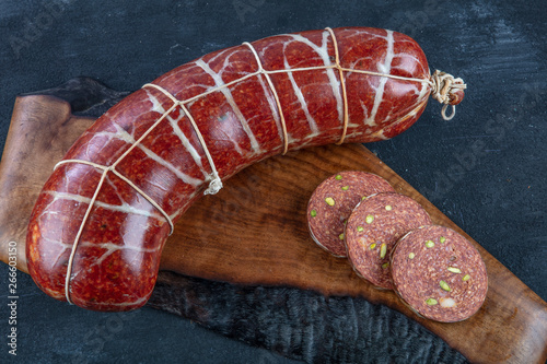 Traditional Hungarian speciality sliced sausage salami on wooden board. Hungarian sausage ( Macar Sucuk). photo