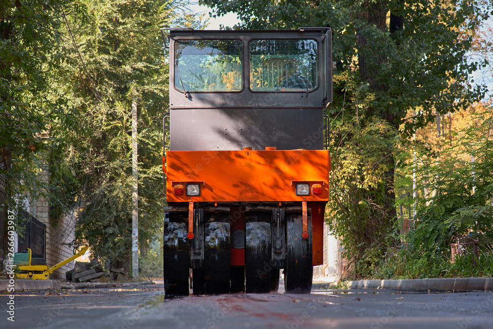 Obraz premium Hot asphalt smokes under the roller. Road construction.Road repair.