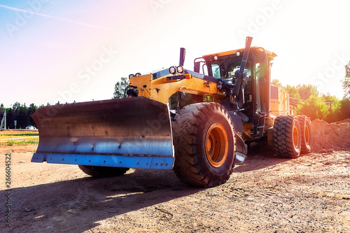 Modern grader in natural conditions at sunset