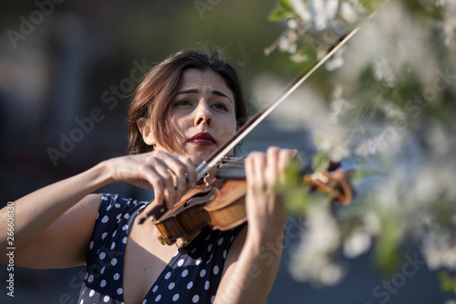 woman playing violin outdoors