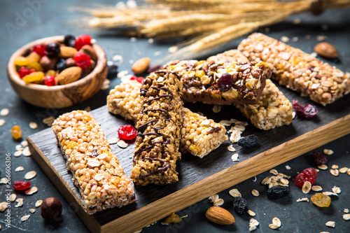 Granola bar with nuts, fruit and berries on black. photo