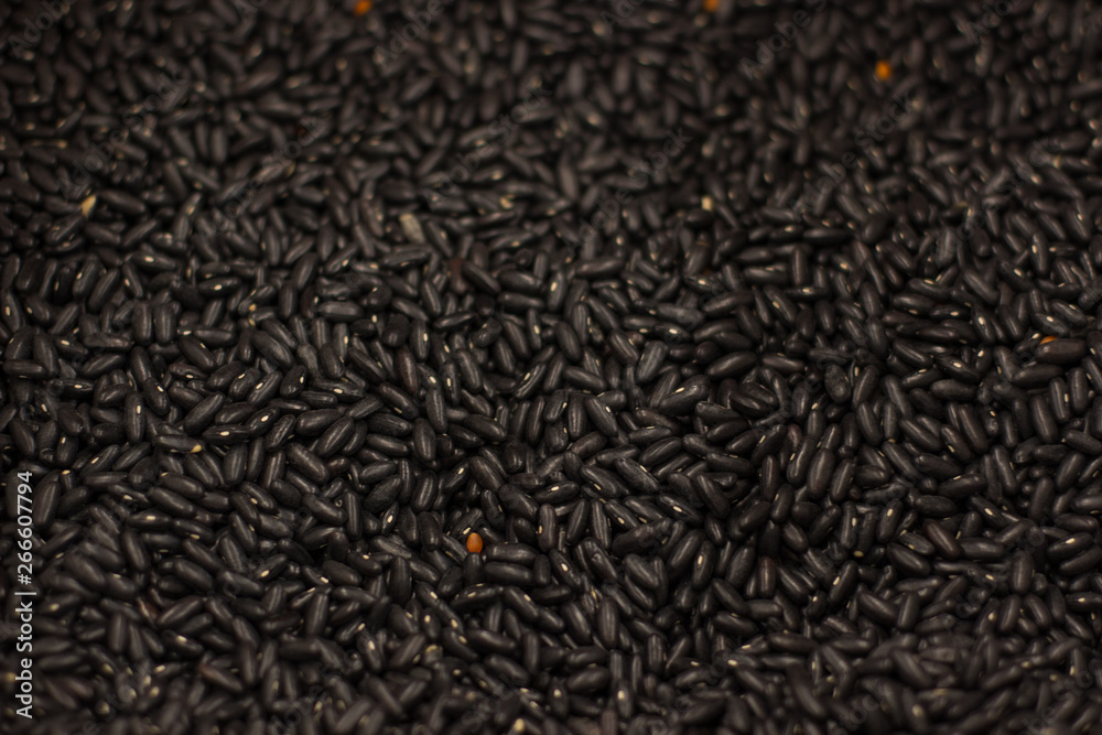 black croup food textured background surface with one yellow different grain in center of foreshortening black croup food textured background surface with one yellow different grain in center of foreshortening