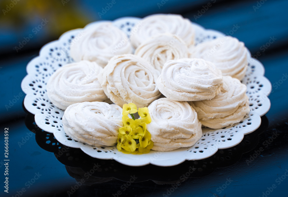 marshmallow in a white plate on a dark background marshmallow in a white plate on a dark background