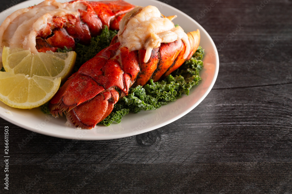 Broiled Lobster Tails on a Bed of Kale with Lemon Slices Broiled Lobster Tails on a Bed of Kale with Lemon Slices