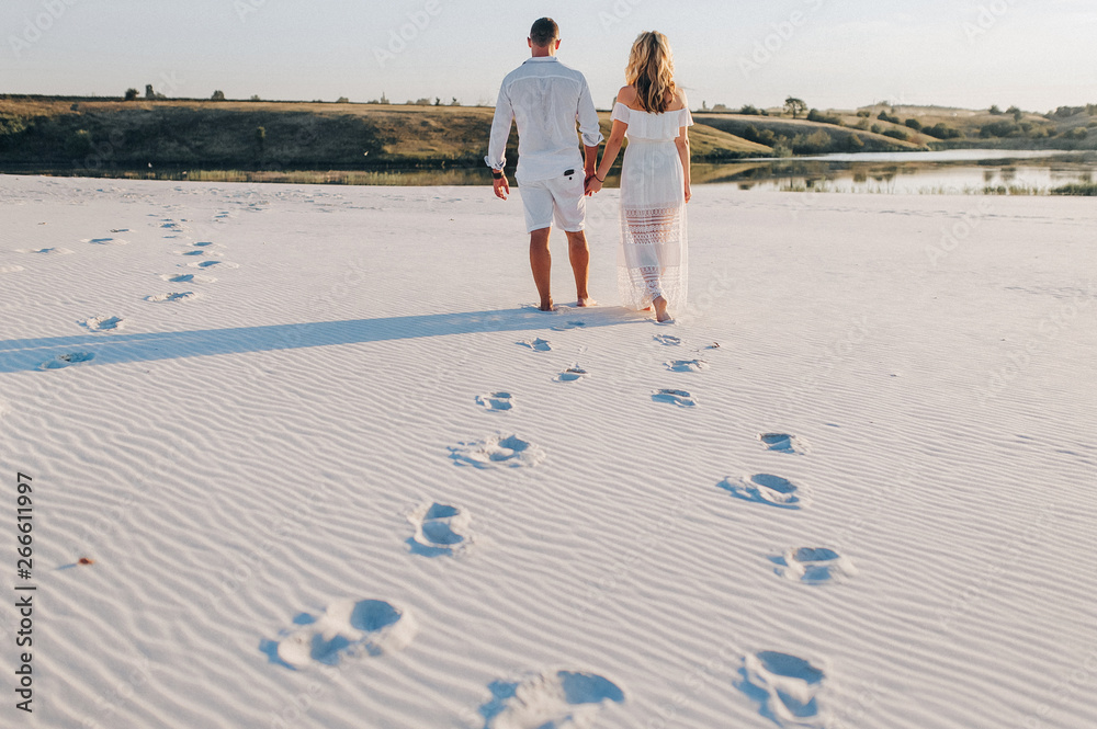 Footprints on the beach sand of a loving couple of a young guy and girl ...