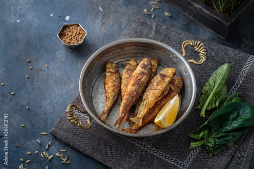 Fried red mullet in copper frying pan, copy space photo