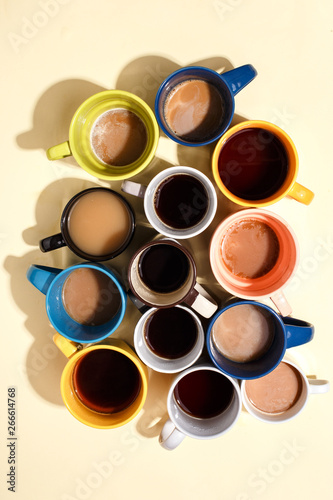 Assorted coffee cups with coffee and on a table. Top view.