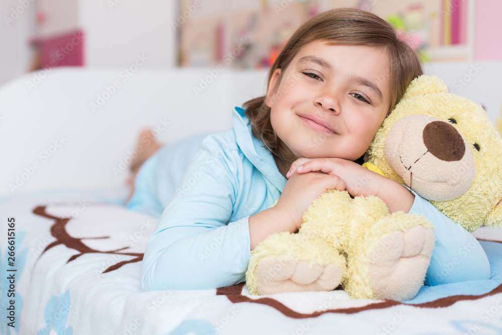Cheerful little cute adorable baby girl playing with yellow teddy bear in her children room. Childhood, leisure kid time, happiness concept Cheerful little cute adorable baby girl playing with yellow teddy bear in her children room. Childhood, leisure kid time, happiness concept