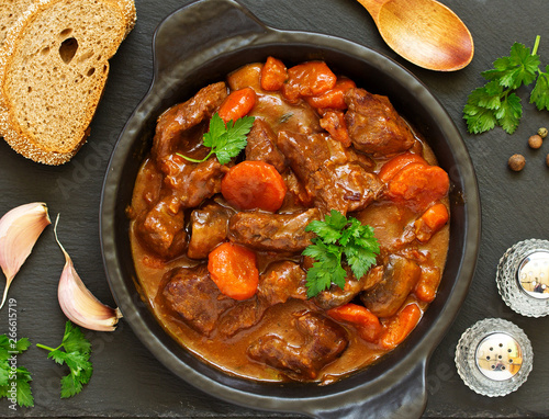 Beef stew in Burgundy. With carrots, onions, peas and champignons in wine. View from above.