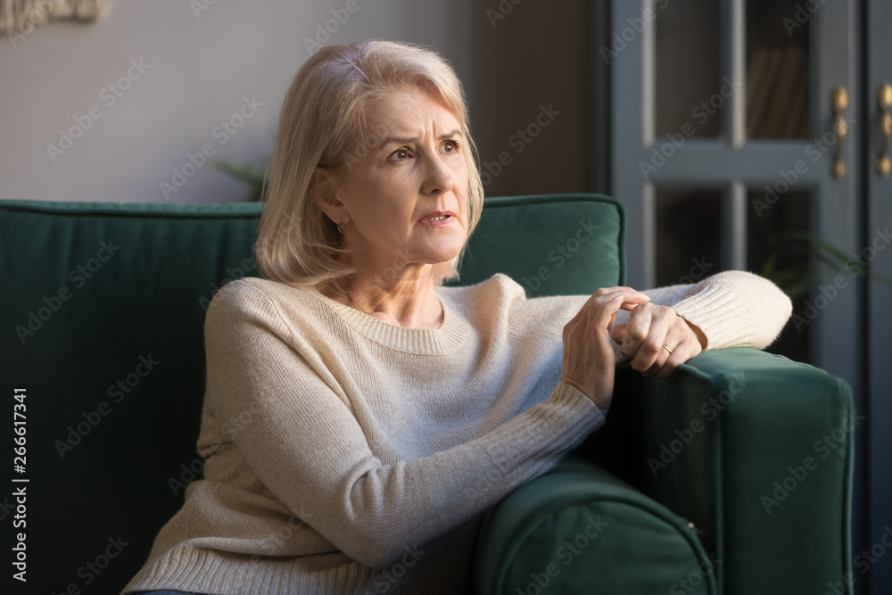 Upset thoughtful grey haired mature woman feeling worried about problems