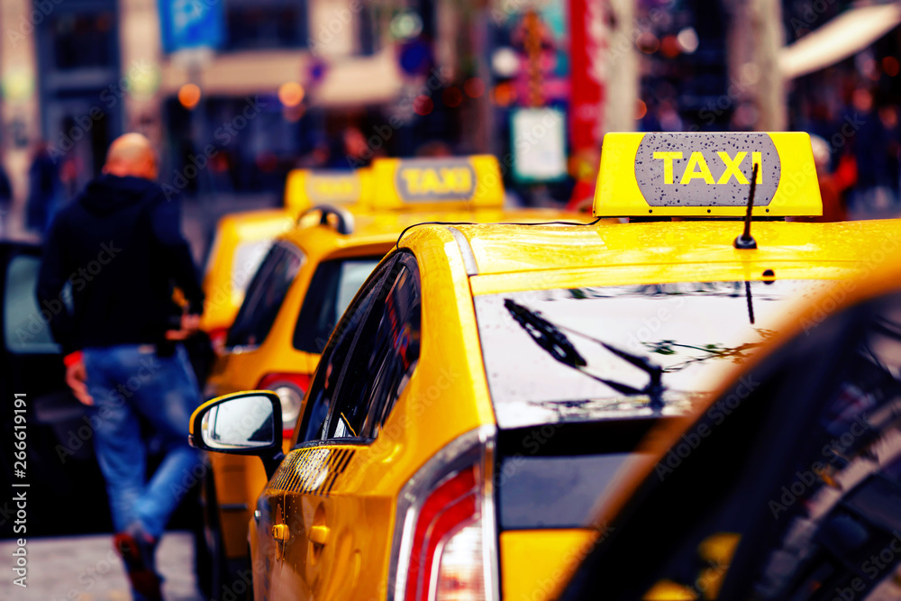 Obraz premium yellow taxi cars in row and blurred bald man get in the cab