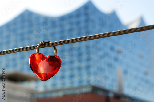 Logo of the elbphilharmonie on a red heart-shaped lock with the elbphilharmonie in the background © Felix Busse Phtgrphy