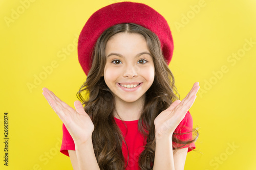Styling of curly hair. Hairdresser service. Kid girl long healthy shiny hair. Perfect curls. Kid cute face with adorable curly hairstyle wear beret hat. Little fashionista. Little girl grow long hair