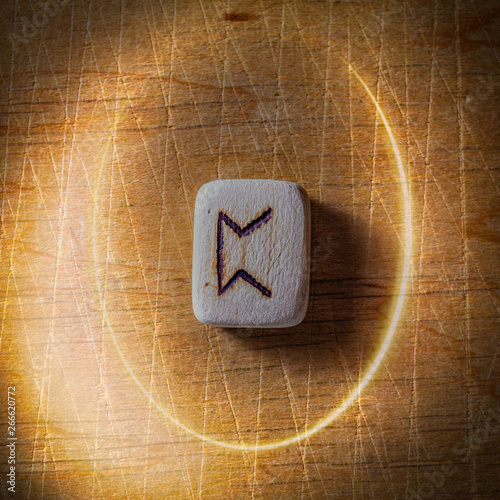 Perthro. Handmade scandinavian wooden runes on a wooden vintage background in a circle of light. Concept of fortune telling and prediction of the future.