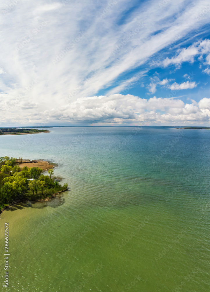 Aerial view of cloudy blue sky over green lake