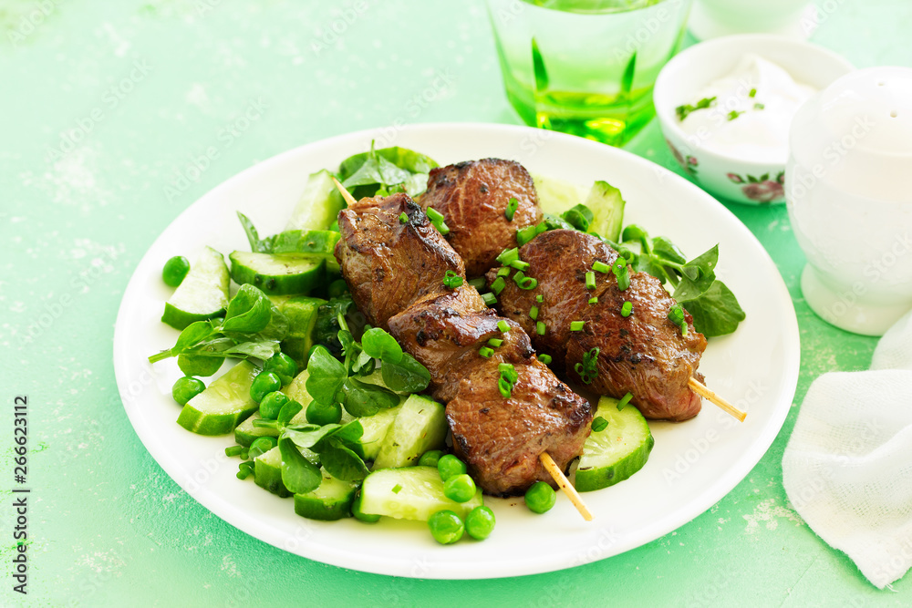 Beef kebab with cucumber and green pea salad. Healthy food.