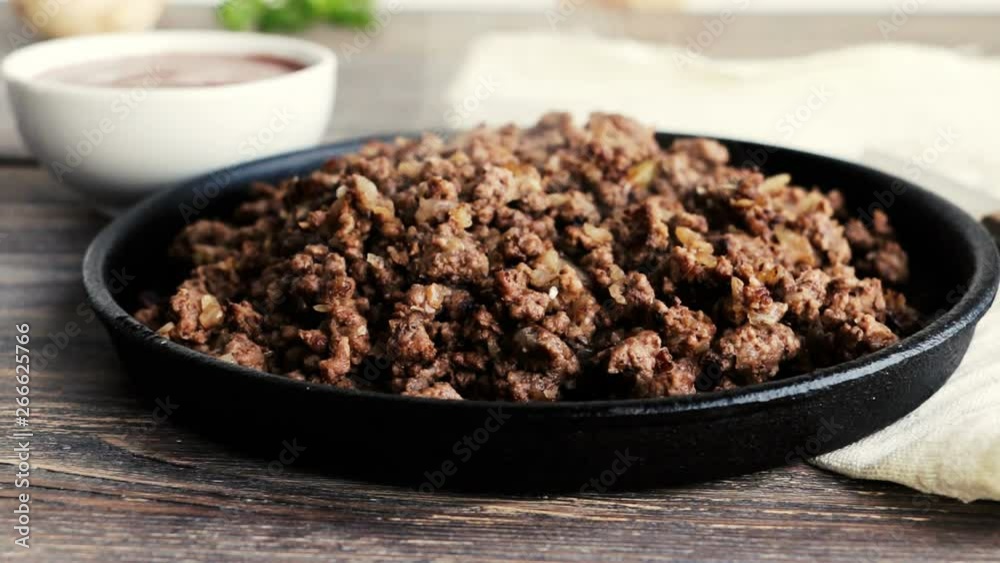 Cooked minced meat with red sauce on wooden table. Ingredients for cooking. Close up. Copy space. Cooked minced meat with red sauce on wooden table. Ingredients for cooking. Close up. Copy space.
